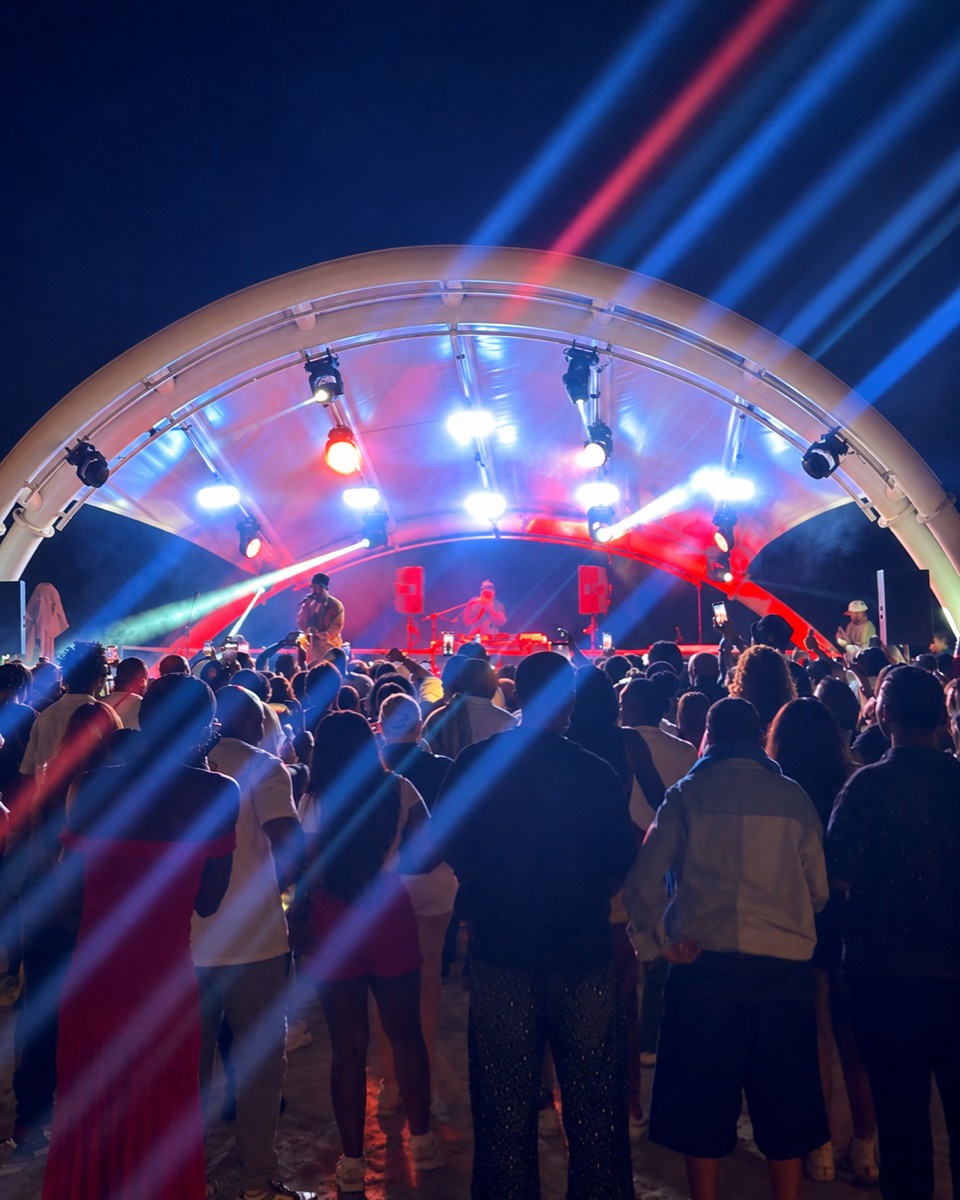 Audience and illuminated live performance stage at GMAT Agency's Cabo Beach Club event